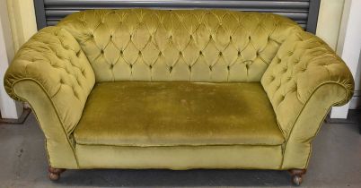 A Victorian green buttoned upholstered double drop end sofa on bun feet.