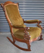 A Victorian carved mahogany framed rocking chair with serpentine seat.