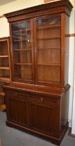 A late Victorian walnut bookcase with glazed top above two drawers and pair of panel doors, width