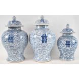 A set of three Chinese blue and white baluster form vases with covers, the larger two 39cm and 38cm,