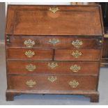 An 18th century oak bureau, the fall front enclosing a fitted interior with sliding well above two