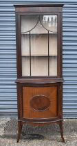 An early 20th century mahogany display cabinet with glazed door above bow fronted door, width
