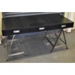 A modern three drawer writing table with simulated crocodile top, three drawers and metal base,