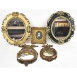 A near pair of decorative black and gilt oval wall mirrors, 44 x 37cm, two small Regency style
