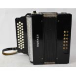 A Hohner 3-row button accordion.