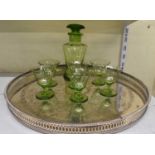 An Art Deco green glass decanter with matching set of six glasses, with large circular silver plated