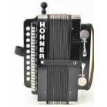 A Hohner Cajun buttoned accordion.