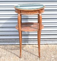 A reproduction French style oval side table with bevelled mirror top above a caned undertier, 44 x