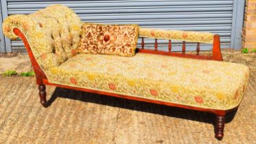 An Edwardian floral button upholstered chaise longue on ring turned supports.