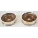 M C HERSEY & SON LTD; a pair of Elizabeth II hallmarked silver bottle coasters, diameter 12.5cm.