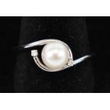 A 9ct white gold cultured pearl and diamond twist ring.