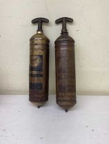 A pair of vintage copper Pyrene fire extinguishers.