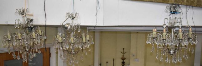 A group of three glass drop chandeliers with metal frames, height approx. 75cm.