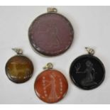 Four assorted Persian intaglio pendants in white metal surrounds, the largest diameter approx. 6cm.