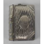 A white metal combined stamp and vesta case modelled as a book, 4.5 x 3.5cm.