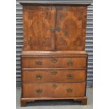 An antique walnut cabinet on chest, the upper section with pair of doors enclosing a fitted interior