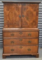 An antique walnut cabinet on chest, the upper section with pair of doors enclosing a fitted interior