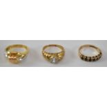A 9ct yellow gold ring set with seven red stones, size M together with two yellow metal rings,