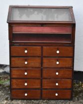 A Victorian mahogany shop display cabinet, the sloping glazed front above ten short drawers, width