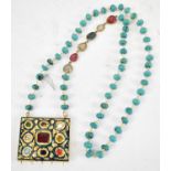 An Eastern turquoise and hardstone necklace suspending a stone set pendant.