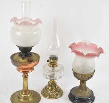 A group of three oil lamps, all with brass and copper bases, height to fitment on tallest 37cm,