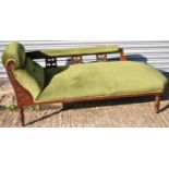 An early 20th century mahogany chaise longue with carved detail and green upholstery.