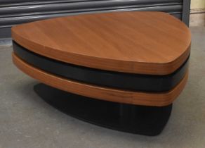 A stylish contemporary coffee table composed of three swivel-out tiers in simulated teak and black