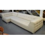 A large modern cream upholstered L-shaped corner sofa on chrome feet.