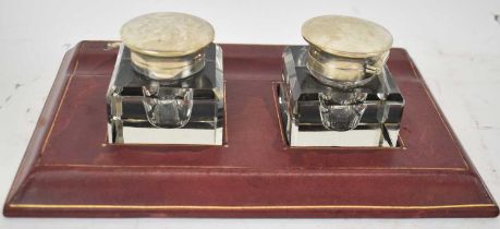 A leather inkstand with pair of silver mounted inkwells for London 1943, width 26cm.