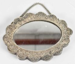 An Eastern 900 grade silver shaped oval mirror, 12 x 8.5cm.