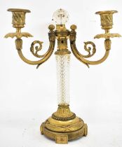 An early 20th century French gilt metal and cut glass three-branch candelabrum, formerly a lamp,