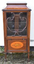 An Edwardian inlaid mahogany music cabinet, the lyre decorated glazed door above a fall front, width