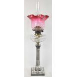 A late 19th century silver plated oil lamp with cut glass well and cranberry glass shade, height