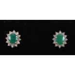 A pair of 9ct yellow gold oval emerald ear studs with diamond dazzle halo, boxed, emeralds approx.