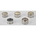 A group of five hallmarked silver napkin rings, four Birmingham and one London 1886, combined