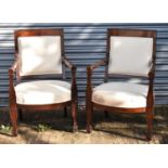 A pair of Continental mahogany framed Empire style open arm elbow chairs with upholstered backs