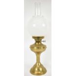 A brass oil lamp, height to top of fitment 32cm, height to top of chimney 59cm.