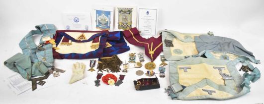 A quantity of Masonic medals, badges and regalia, to include blue aprons and large red and yellow