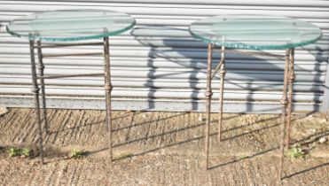 A pair of contemporary side tables with circular clear and etched glass tops on metal bases,