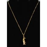 A 9ct yellow gold pendant modelled as a penguin, suspended on a 9ct yellow gold necklace, combined