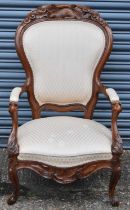 A spoon back open arm chair, the wooden frame carved with a beaver.