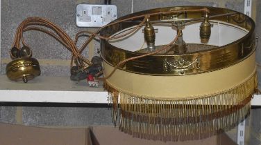 An early 20th century brass circular three-light ceiling light with suspended beaded decoration to