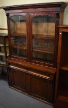 A large 19th century mahogany bookcase with pair of glazed doors above two drawers and pair of