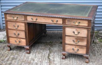 An early 20th century mahogany twin pedestal nine drawer desk with green tooled leather inset top,