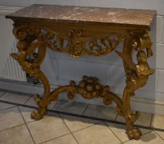 A gilt wood console table with veined marble top above pierced mask centred frieze with winged
