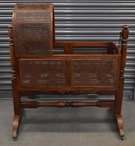 A late 19th century mahogany child's bow top swinging bergère cradle, width 105cm, height to tallest