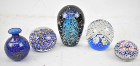 A group of four decorative paperweights, together with a small Italian blue glass vase decorated