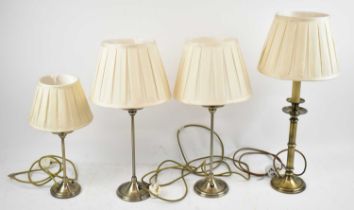 A pair of modern brass effect table lamps, another smaller lamp and a similar brushed brass effect