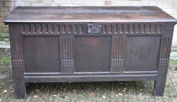 An 18th century oak plank top coffer, with carved decoration to the front, width 150cm.