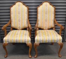 A pair of walnut framed Continental elbow chairs raised on knee carved cabriole front legs to pad